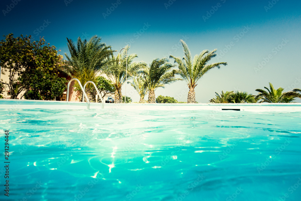 Empty swimming pool against palm tree, Crete, Greece Empty swimming pool against palm tree, Crete, Greece