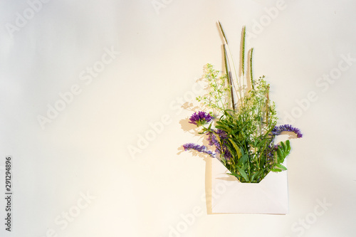 Bouquet of wildflowers on a white background. For design of summer background, green decorative elements, copy space for text. Top view image.