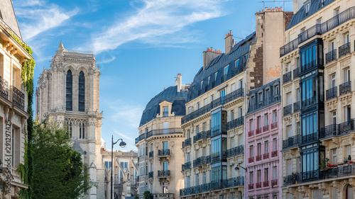 Paris, charming street and buildings, typical parisian facades in the Marais, with Notre-Dame cathedral in background photo