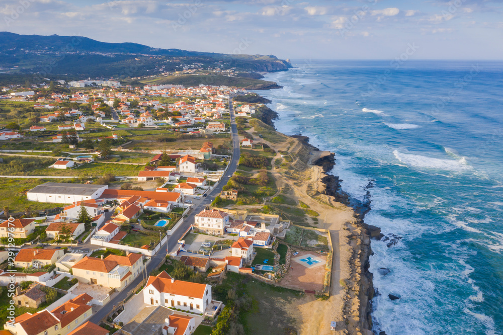 Aerial view of small town with red roofs on coastline Atlantic ocean. Top View of Azenhas Do Mar, Sintra, Portugal