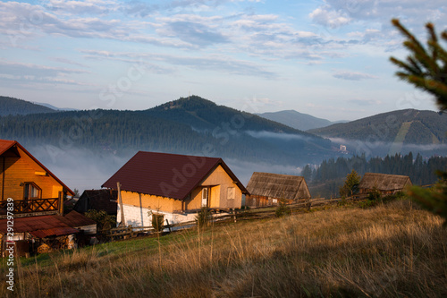 Early foggy morning in the mountains. Carpathians, Bukovel, lawn houses.