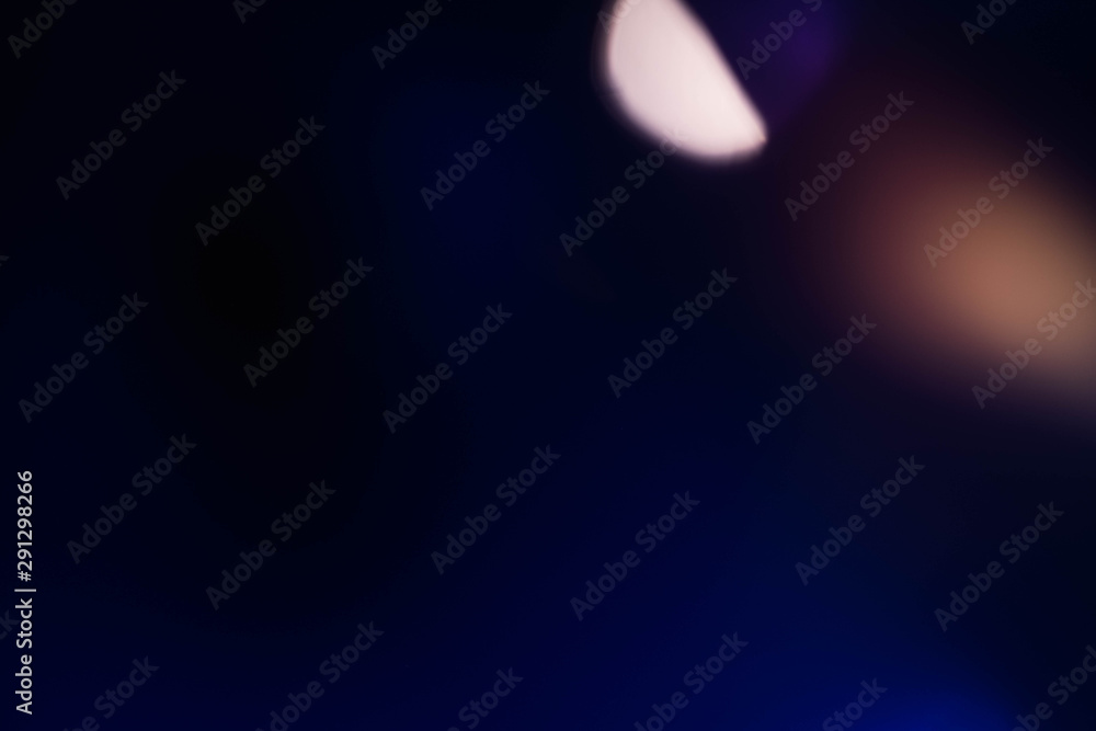 Defocused navy blue abstract art background. Colored lens flare. Blur ight lights effect.