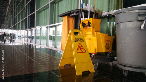 The warning signs cleaning and caution wet floor in the building and janitorial car. photo