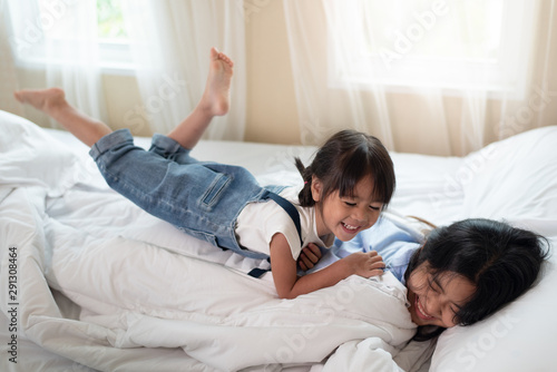 Happy Asian family loving children, kid and her sister relaxing together in bed © surachetkhamsuk