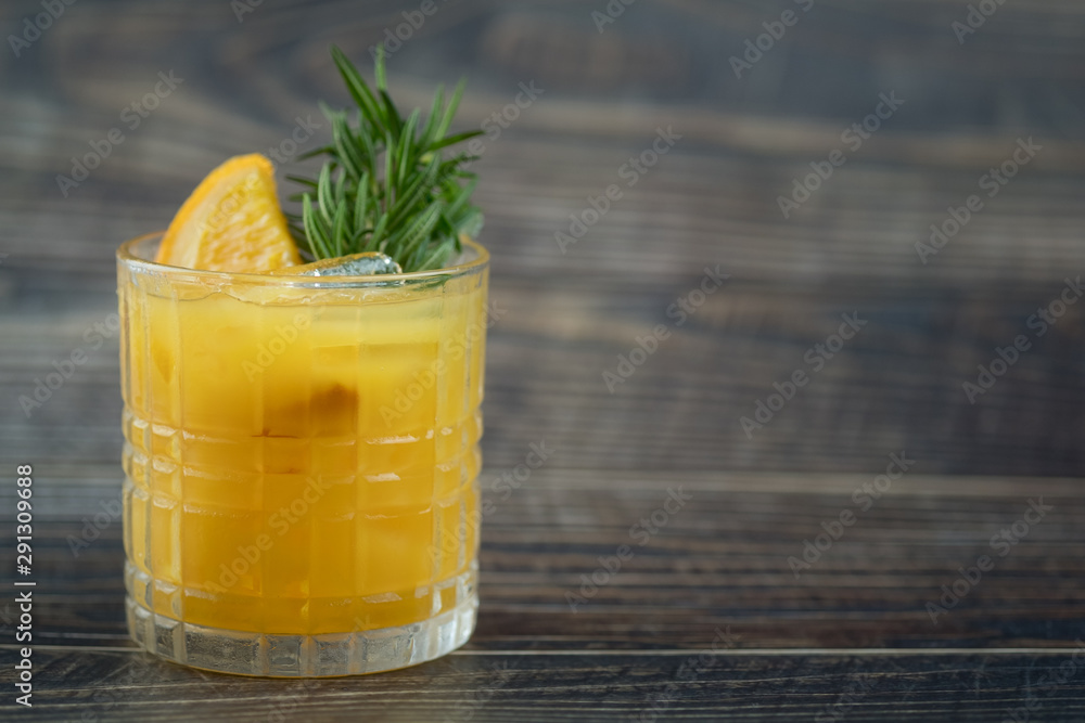 Fresh summer cocktail with orange juice and ice cubes in glass Fresh summer cocktail with orange juice and ice cubes in glass