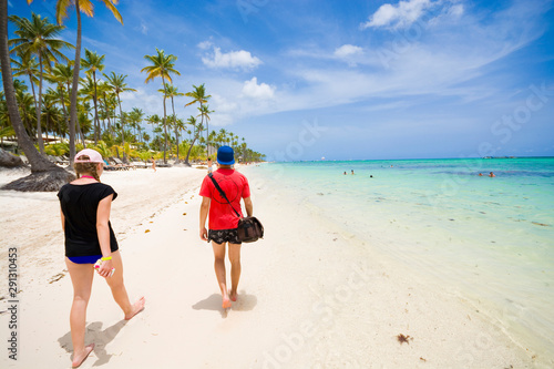 Teenagers walking along san...