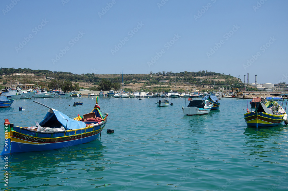 Marsaxlokk, Malta. Luzzu traditional eyed colorful boats in the harbor of fishing village, Mediterranean Sea.