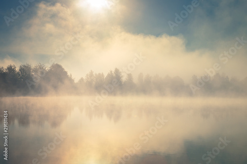 Beautiful foggy morning. Lake coast. Fog over autumn lake water. © stone36