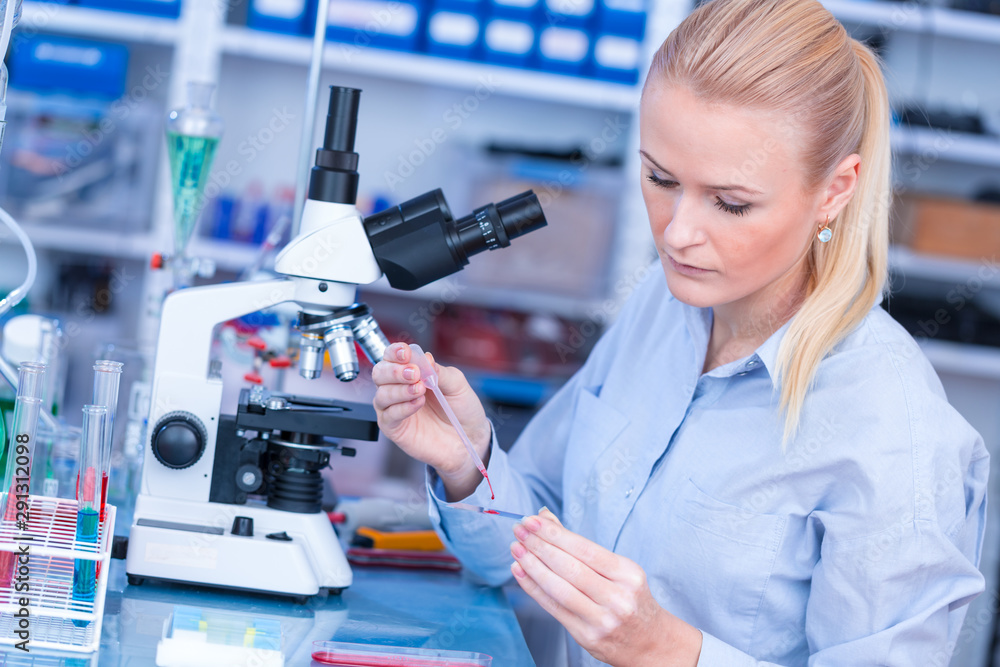 Laboratory assistant uses a polarizing microscope in a microbiological laboratory Laboratory assistant uses a polarizing microscope in a microbiological laboratory