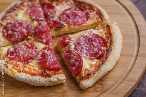 sliced pepperoni mini pizza on cutting board close up