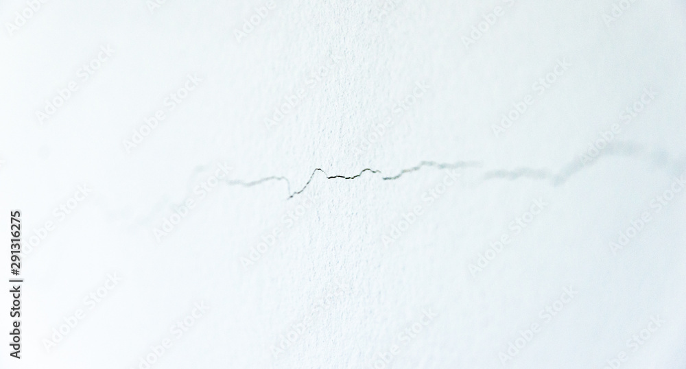 Crack on the wall. Shift foundations on the building and extended bricks. Building problems or consequence of earthquake in the active area. White wall shows everything. Risk of building collapsing Crack on the wall. Shift foundations on the building and extended bricks. Building problems or consequence of earthquake in the active area. White wall shows everything. Risk of building collapsing