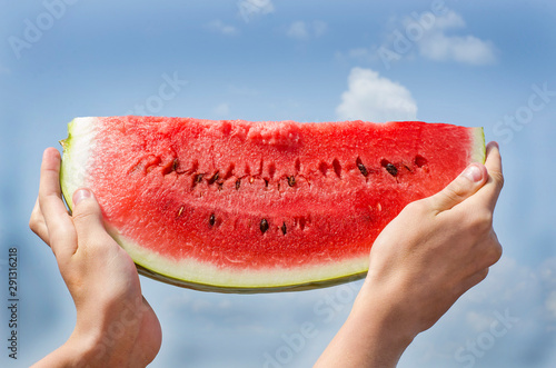 A slice of watermelon against a blue sky. Summer dessert, watermelon day.