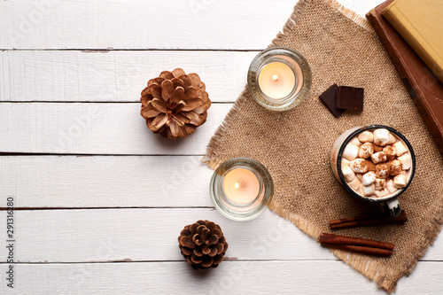 Photos Cup of hot cocoa or hot chocolate with marshmallows and cinnamon sticks on wooden background with burning candles