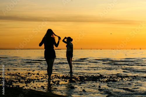 Girls couple on the beach at sunset