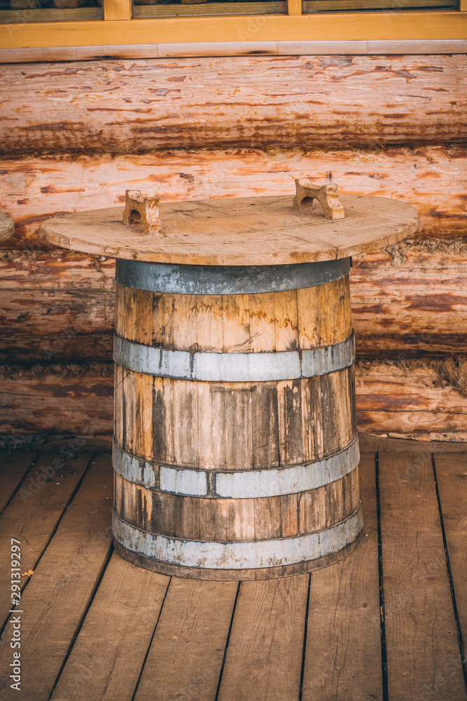 wooden barrels next to a wooden log house wooden barrels next to a wooden log house