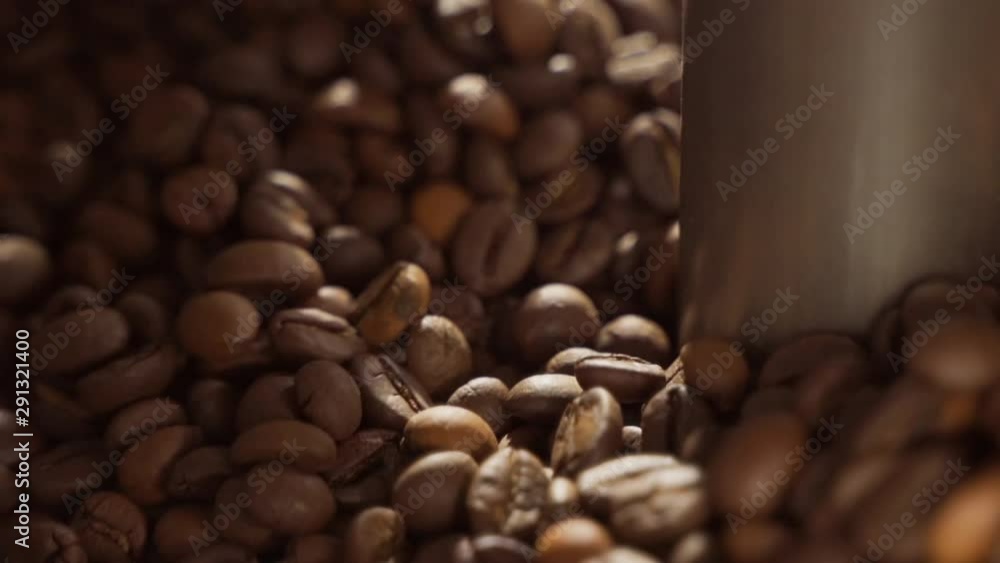 Freshly roasted coffee beans from a large coffee roaster. Roasting coffee beans at Roasting equipment. Coffee beans are spinning in a machine. Freshly roasted coffee beans from a large coffee roaster. Roasting coffee beans at Roasting equipment. Coffee beans are spinning in a machine.
