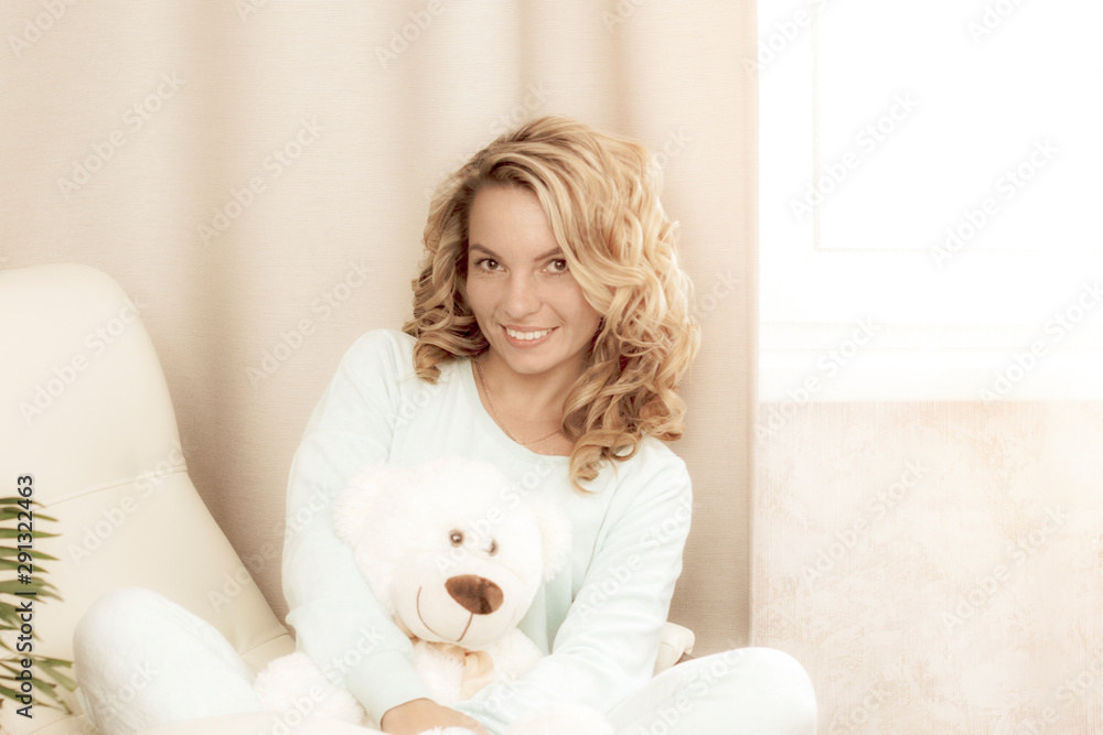 Portrait of a beautiful, sexy, sweet, gentle girl with a white cozy Bear at home in pajamas. Portrait of a beautiful, sexy, sweet, gentle girl with a white cozy Bear at home in pajamas.