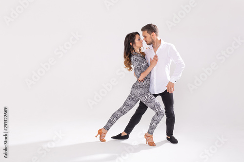 Young couple dancing social latin dance bachata, merengue, salsa. Two elegance pose on white background with copy space