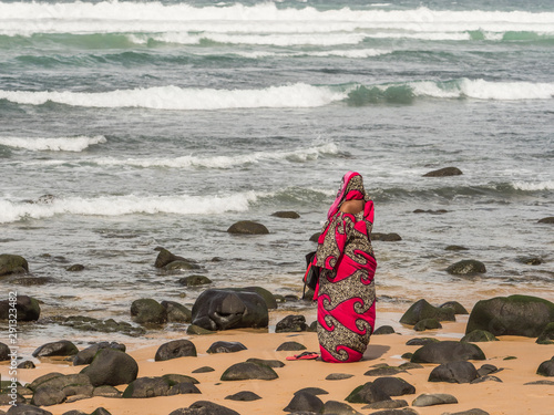 A figure of a Muslim woman in a red boubou photo