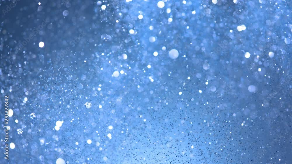 Super slow motion of glittering blue particles on black background. Shallow depth of focus. Filmed on high speed cinema camera, 1000 fps. Super slow motion of glittering blue particles on black background. Shallow depth of focus. Filmed on high speed cinema camera, 1000 fps.