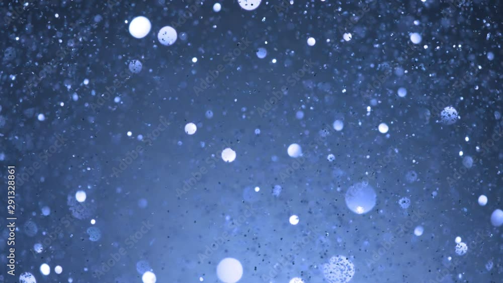 Super slow motion of glittering blue particles on black background. Shallow depth of focus. Filmed on high speed cinema camera, 1000 fps. Super slow motion of glittering blue particles on black background. Shallow depth of focus. Filmed on high speed cinema camera, 1000 fps.