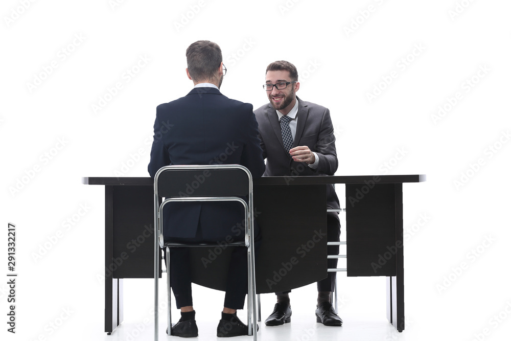 two businessmen talking, sitting at his Desk