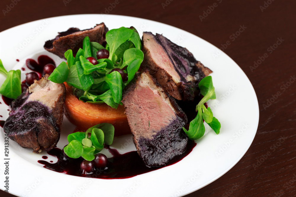 baked duck fillet in a sauce with herbs and berries in a plate baked duck fillet in a sauce with herbs and berries in a plate
