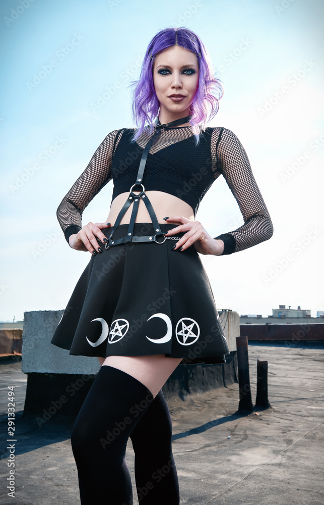 Portrait of beautiful gothic girl on housetop. Pastel goth with violet  (purple) hair in black clothes Stock Photo