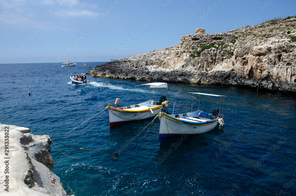 boats moored in the Wied iz-Zurrieq harbor near the Blue Grotto sea caves in Malta.