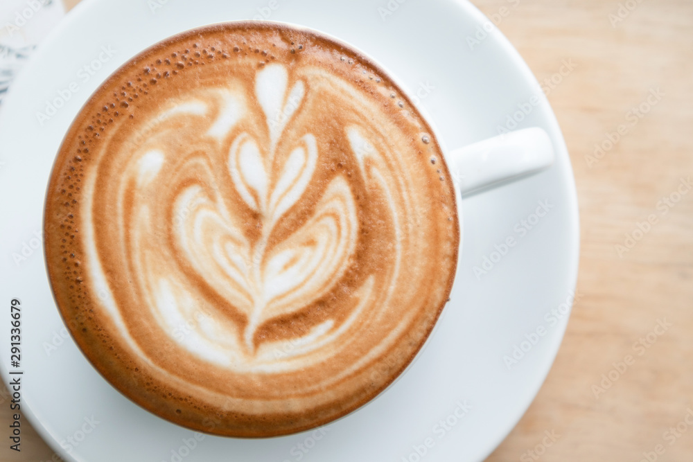 Coffee cup latte art in heart shape on wooden table.Frothy drink for coffee break after working or weekend meeting Coffee cup latte art in heart shape on wooden table.Frothy drink for coffee break after working or weekend meeting