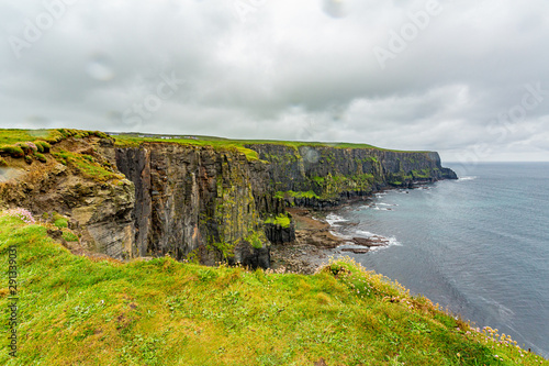 Irish landscape of the rocky cliffs along the coastal walk route from Doolin to the Cliffs of Moher, geosites and geopark, Wild Atlantic Way, rainy day in county Clare in Ireland