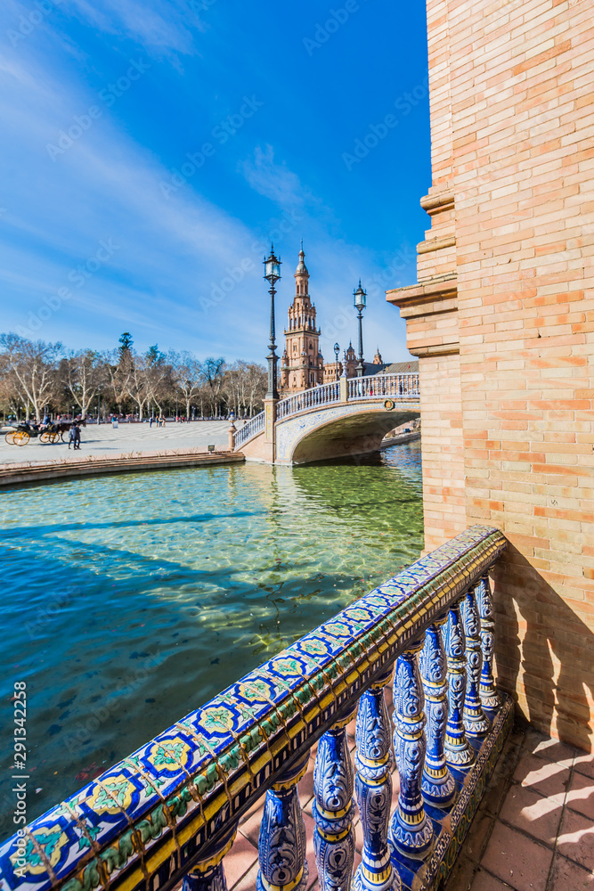 Side view of the canal and bridge in the plaza de españa in seville on a beautiful sunny day and a blue sky in the background