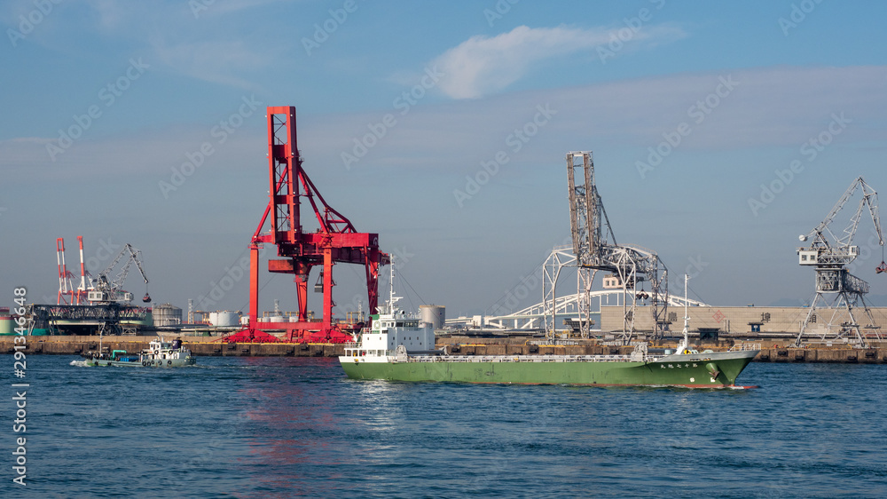 Сargo ship in Osaka Japan in front of floating cranes. Freighter ship in Osaka Japan