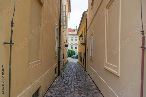 Very narrow aisle between houses facing the street on a sunny summer day