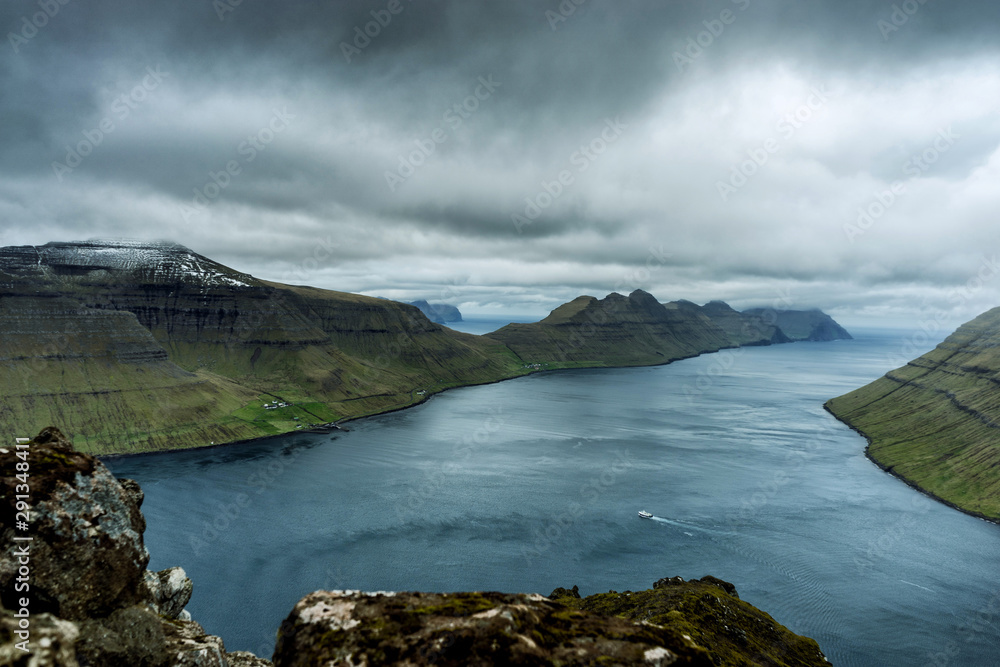 Spectacular views of the scenic fjords on the Faroe Islands with cloud-covered mountains. Spectacular views of the scenic fjords on the Faroe Islands with cloud-covered mountains.