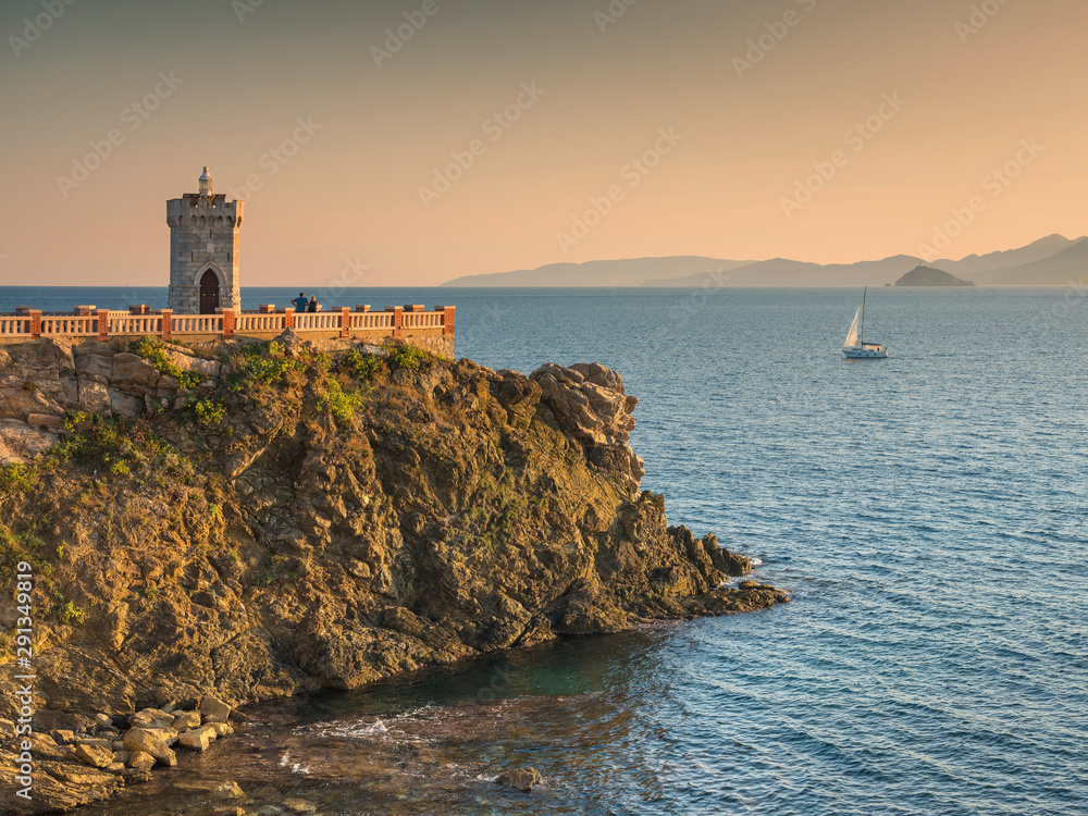 View to lighthouse and sail yacht at sea in sunset time in Piombino in Italy