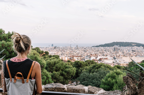Rear view of a blond woman looking at barcelona city view © carles