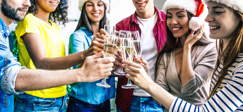 Happy New Year! Close-up photo group of diverse people in casual clothes cheering with champagne flutes in the white studio.