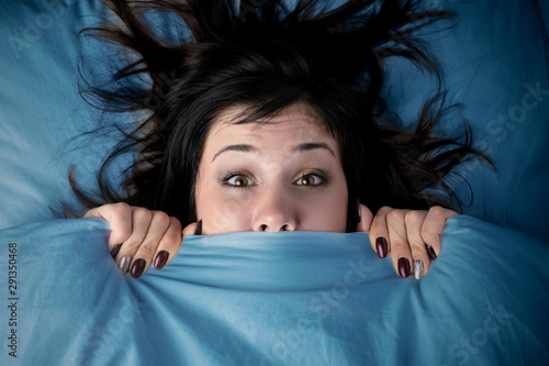 Fotografía girl hides her face under the covers in bed