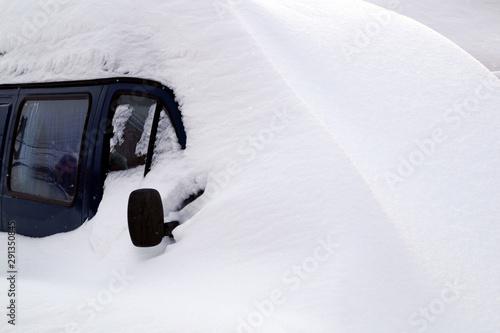 The car is covered in snow after heavy snowfall.