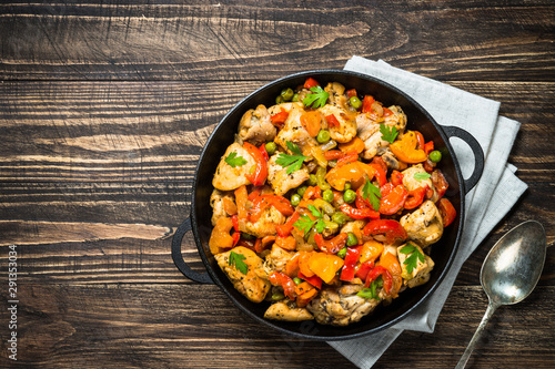 Chicken Stir fry with vegetables on wooden table.