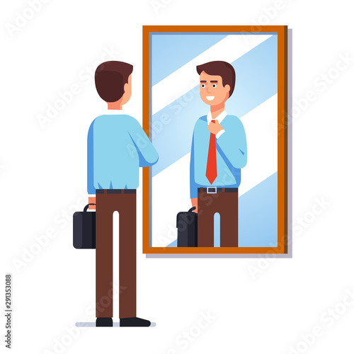 Bbusiness man looking at reflection in wall mirror