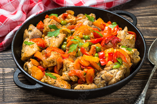 Chicken Stir fry with vegetables on wooden table.