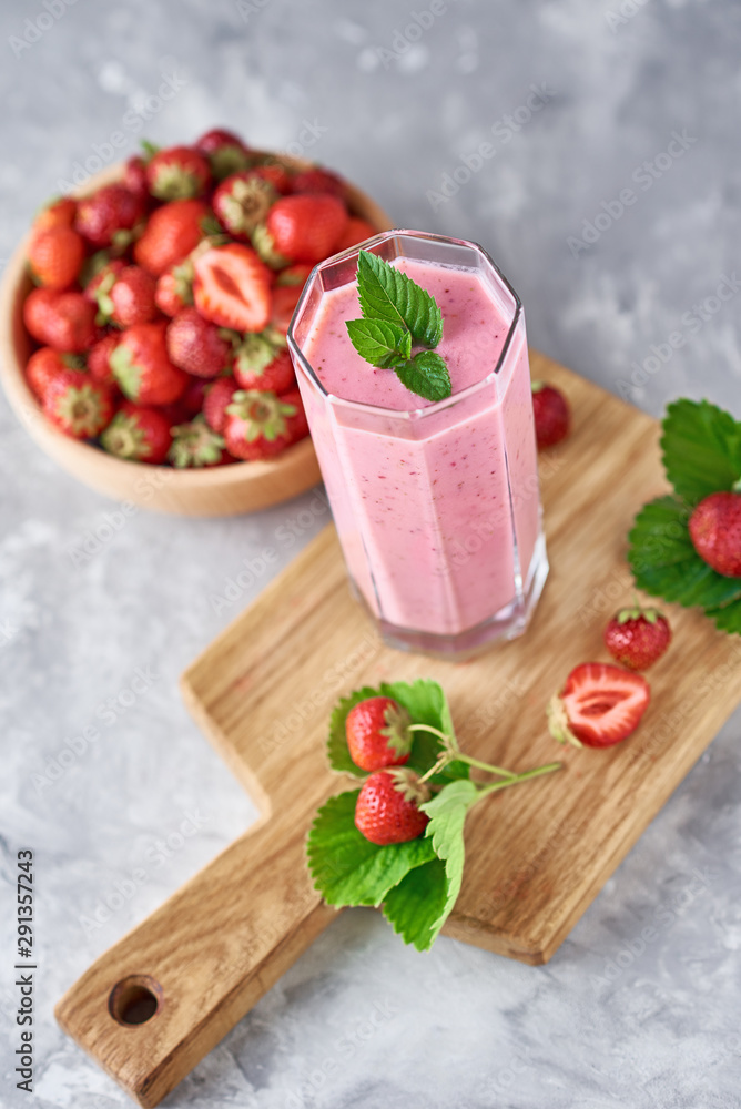 Strawberry milk shake in a glass jar and fresh strawberries with leaves Strawberry milk shake in a glass jar and fresh strawberries with leaves
