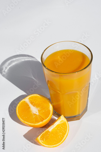 Glass of orange juice with slices orange deep shadows isolated on white background