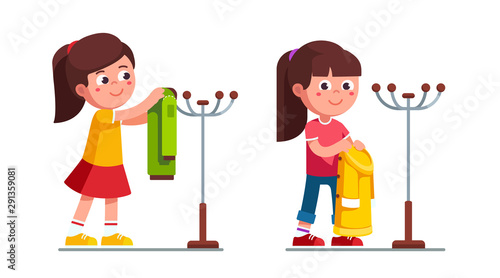 Little girls holding, hanging coat on hanger stand