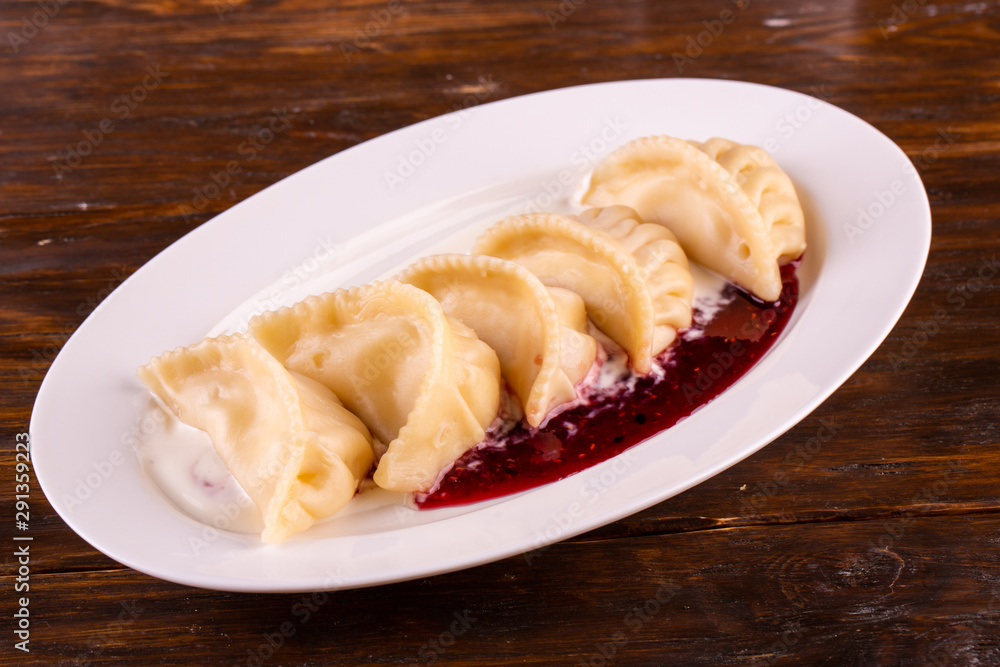 Cottage cheese dumplings, are served with sour cream and jam