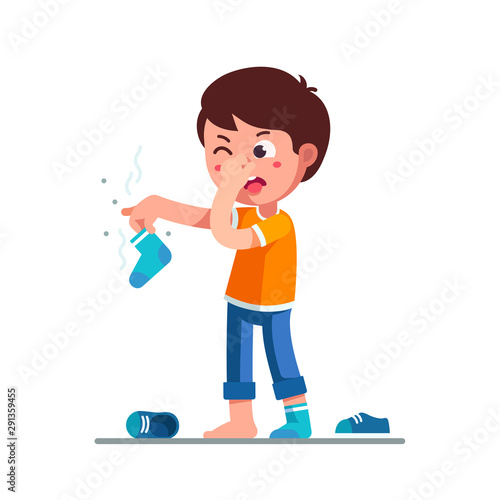 Standing boy holding dirty smelling sock in hand