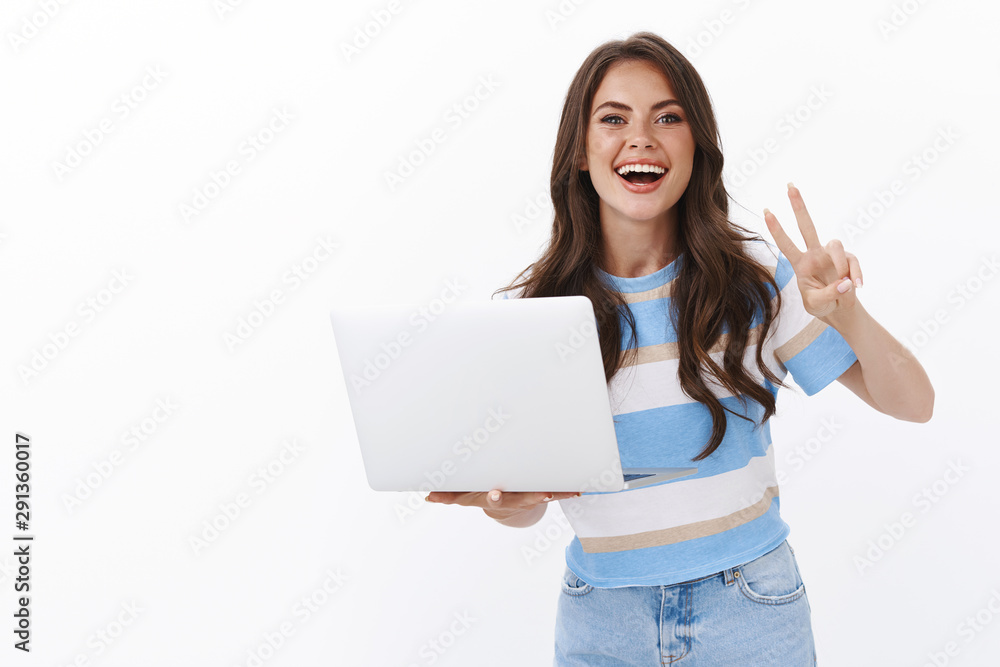 Optimistic gorgeous female freelancer, lead van life lifestyle, hold laptop working remote from office, show peace, victory sign, smiling joyfully, plan own schedule, studying in co-working space Optimistic gorgeous female freelancer, lead van life lifestyle, hold laptop working remote from office, show peace, victory sign, smiling joyfully, plan own schedule, studying in co-working space