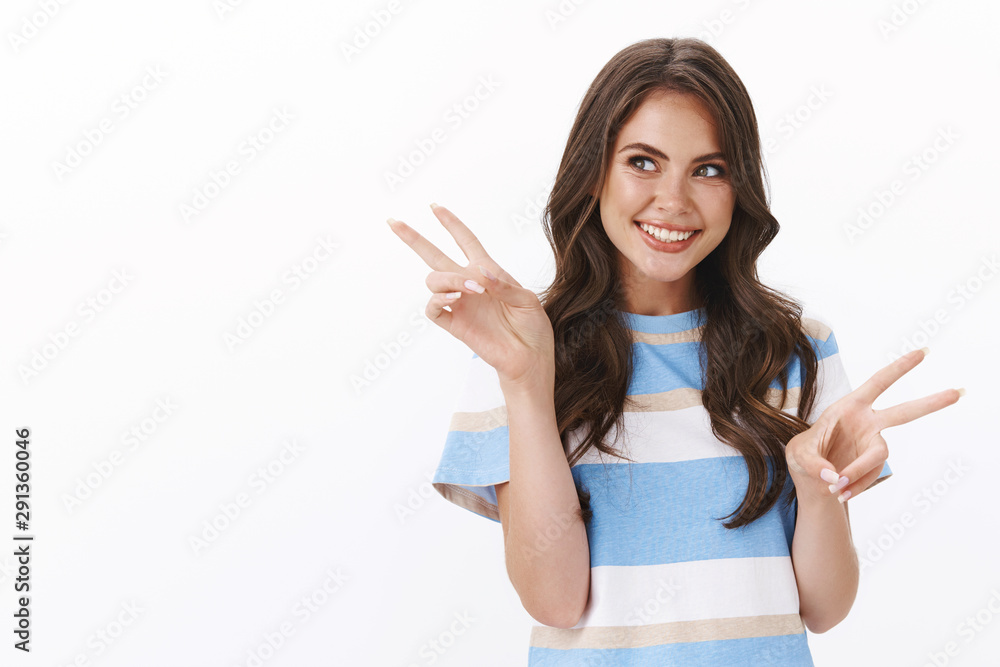 Enthusiastic cute sensual brunette woman with long curly hair making flirty gazes left copy space, smiling happily show peace victory sign, enjoy summer vacation, look satisfied, white background Enthusiastic cute sensual brunette woman with long curly hair making flirty gazes left copy space, smiling happily show peace victory sign, enjoy summer vacation, look satisfied, white background